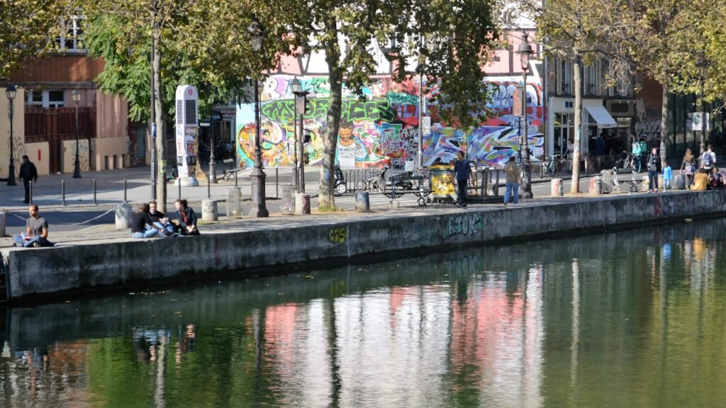 people walking on sidewalk near body of water during daytime